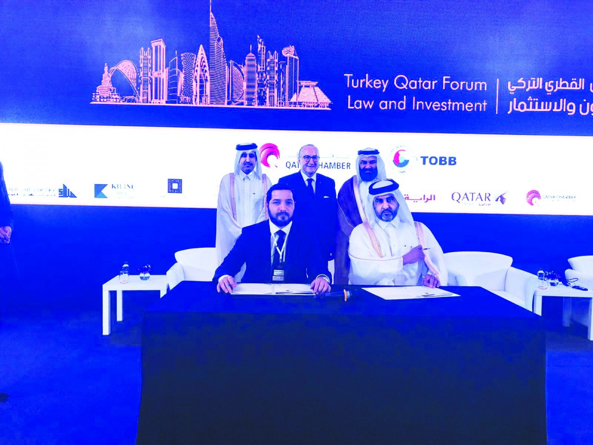  Qatar Chamber Board Member Dr Mohamed Jawhar Al Mohamed (standing right) and QC Director General Saleh bin Hamad Al Sharqi (standing left) witnessing the signing of the two cooperation agreements during the Qatar-Turkey Law & Investment Forum which opene