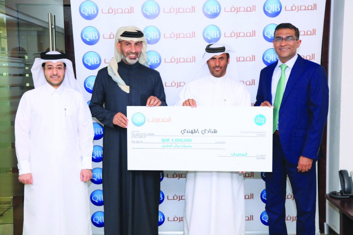 D Anand (right), QIB’s Personal Banking Group General Manager, and other QIB officials presenting cheque to the winner.