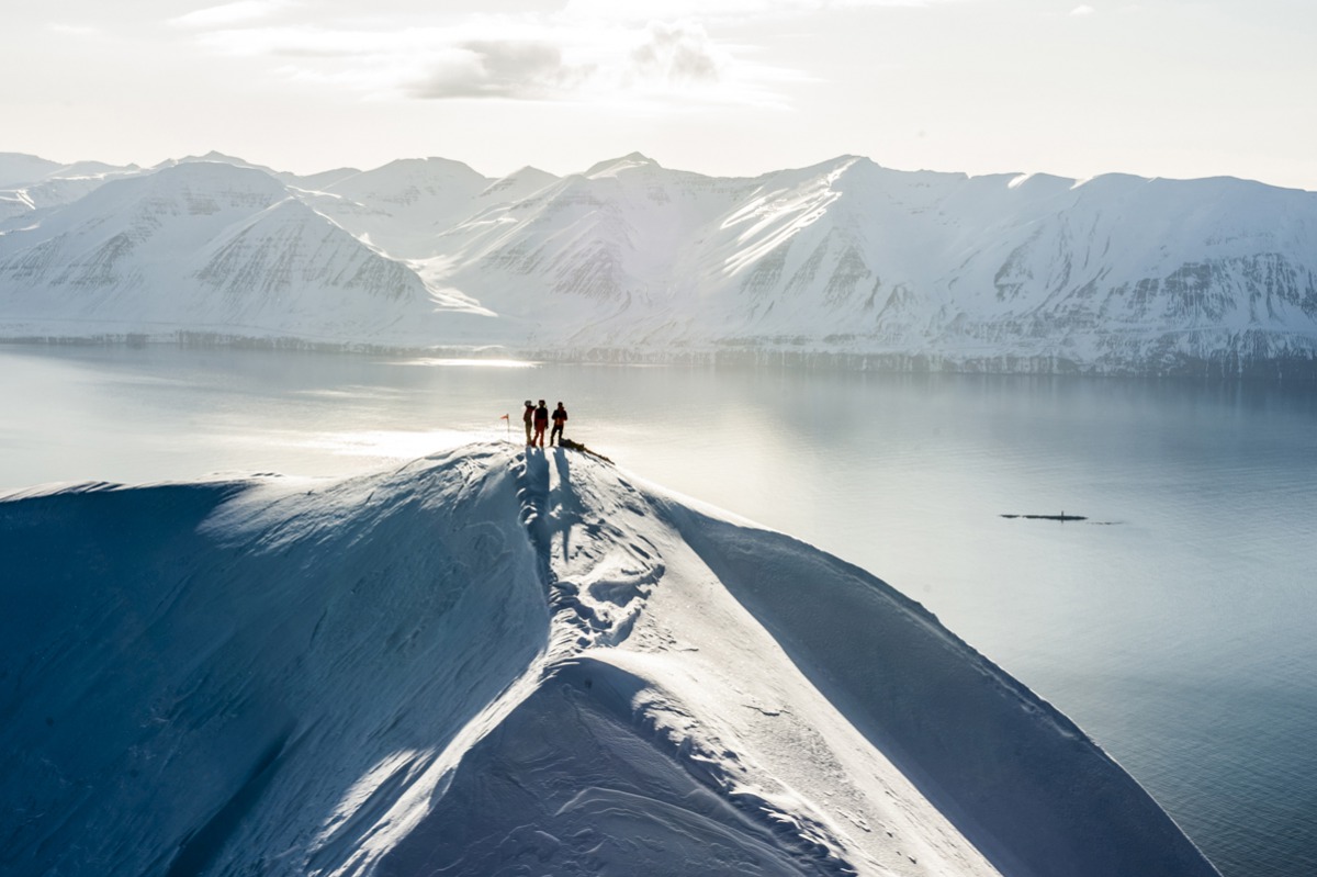  Skiers are dropped off by helicopter atop a mountain in Iceland.  Arctic Heli Skiing Iceland. 