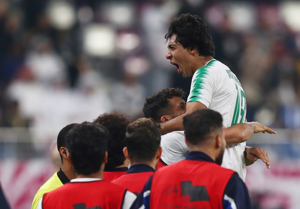 Iraq's Mohammad Qasem celebrates scoring their first goal with teammates. Reuters/Ibraheem Al Omari