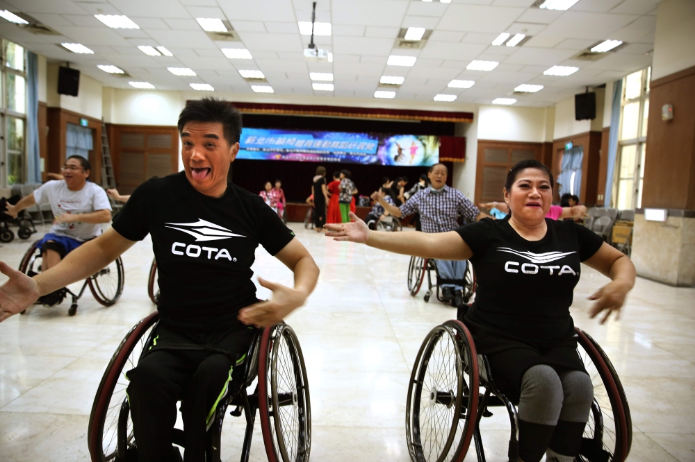 This photo taken on November 9, 2019 shows wheelchair dancers Ivy Huang (R) and Vincent Kuo (front L) with members of the Taiwan Wheelchair Dance Sport Association training for a performance at the Community Centre in New Taipei City. AFP / Hsu Tsun-hsu 