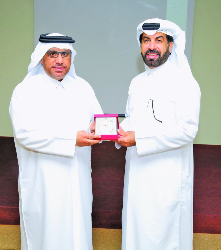 Rashid Al Mansoori (right), CEO of Qatar Stock Exchange,  presenting a memento to Dr. Hashem Al Sayyid during the event.