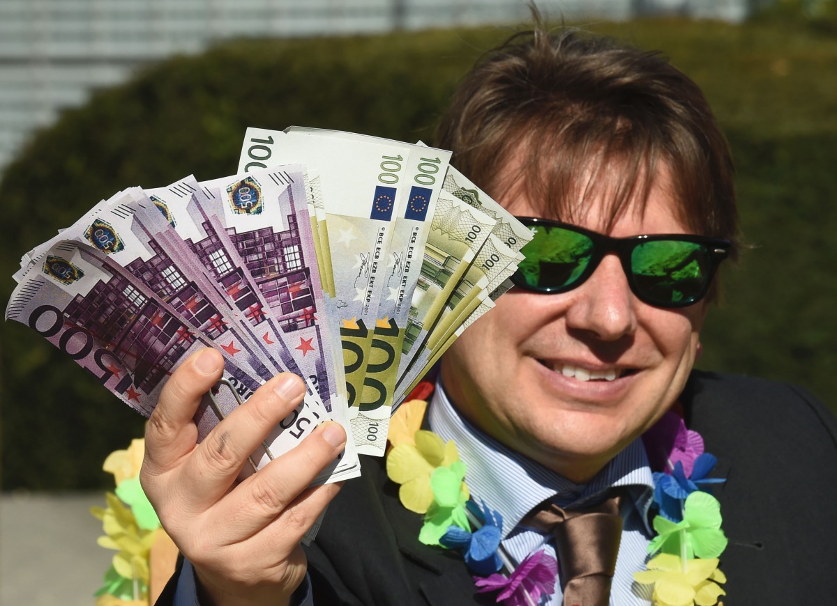 FILE PHOTO: An activist performs as a client of an offshore company during a protest of Oxfam and Transparency International in front of the European Commission headquarters in Brussels on April 12, 2016. AFP / John Thys