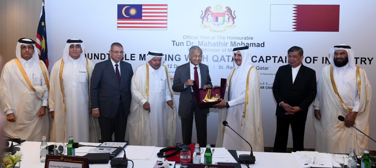 The visiting Malaysian Prime Minister H E Dr Mahathir Mohamad (fourth right) receiving a memento from the Chairman of Qatar Chamber, Sheikh Khalifa bin Jassim Al Thani, after the roundtable meeting with Qatari business leaders held at the St Regis Hotel i