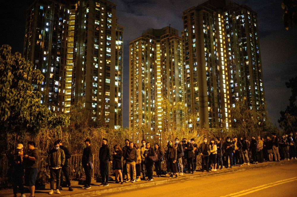 Mourners queue along a road as they wait to pay their respects at the memorial service for Alex Chow, 22, who died last month from head injuries sustained during a fall inside a multi-storey carpark where police and protesters were clashing, at Po Fook Hi