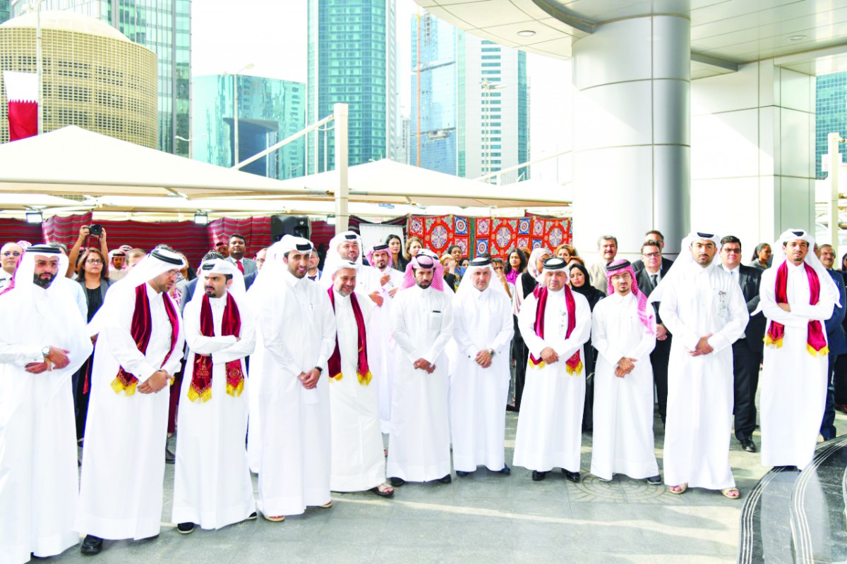 QFC officials and staff gather at the QFC Tower premises to celebrate Qatar National Day, yesterday.