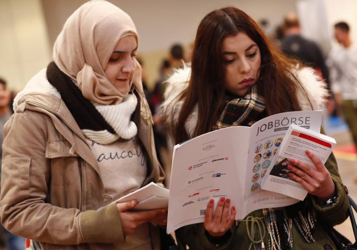 Two women visit the second job fair for migrants and refugees in Berlin, Germany, January 25, 2017. Reuters/Fabrizio Bensch 