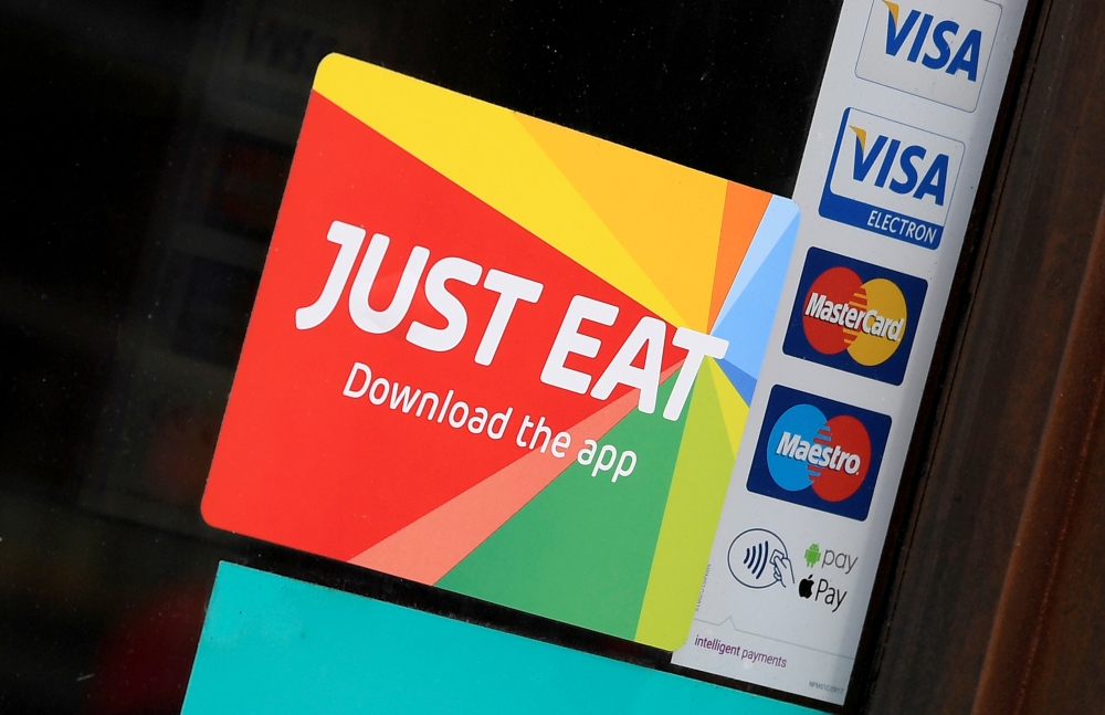 Signage for Just Eat is seen on the window of a restaurant in London, Britain, August 5, 2019. Reuters/Toby Melville