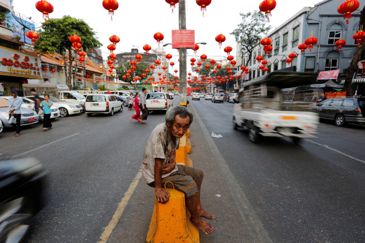 FILE PHOTO: A man sits under lanterns and decorations on a street ahead of the Chinese Lunar New Year in Chinatown, Yangon, Myanmar. January 23, 2017. Reuters / Soe Zeya Tun