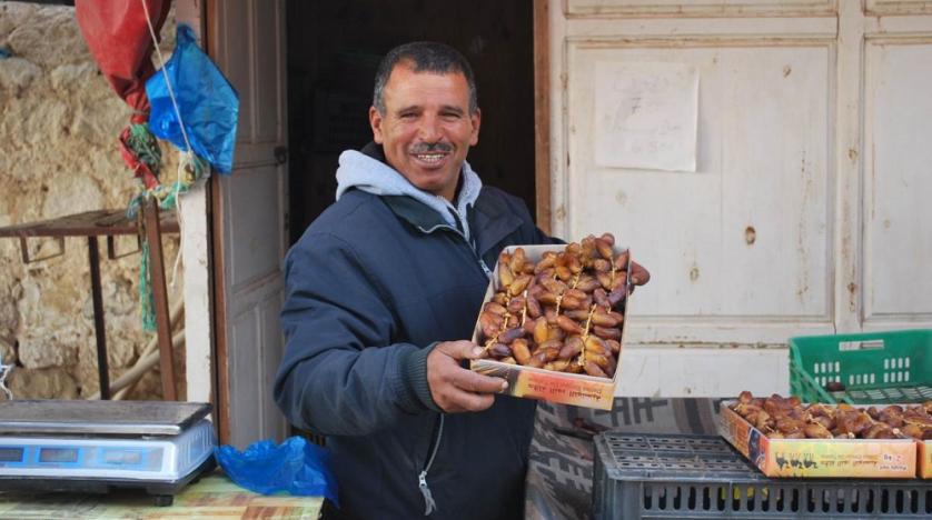 Lazhar Ghiloufi, a date seller in Kebili, south Tunisia, holds up a box of good quality deglet nour dates, December 2, 2019. Thomson Reuters Foundation/ Layli Foroudi