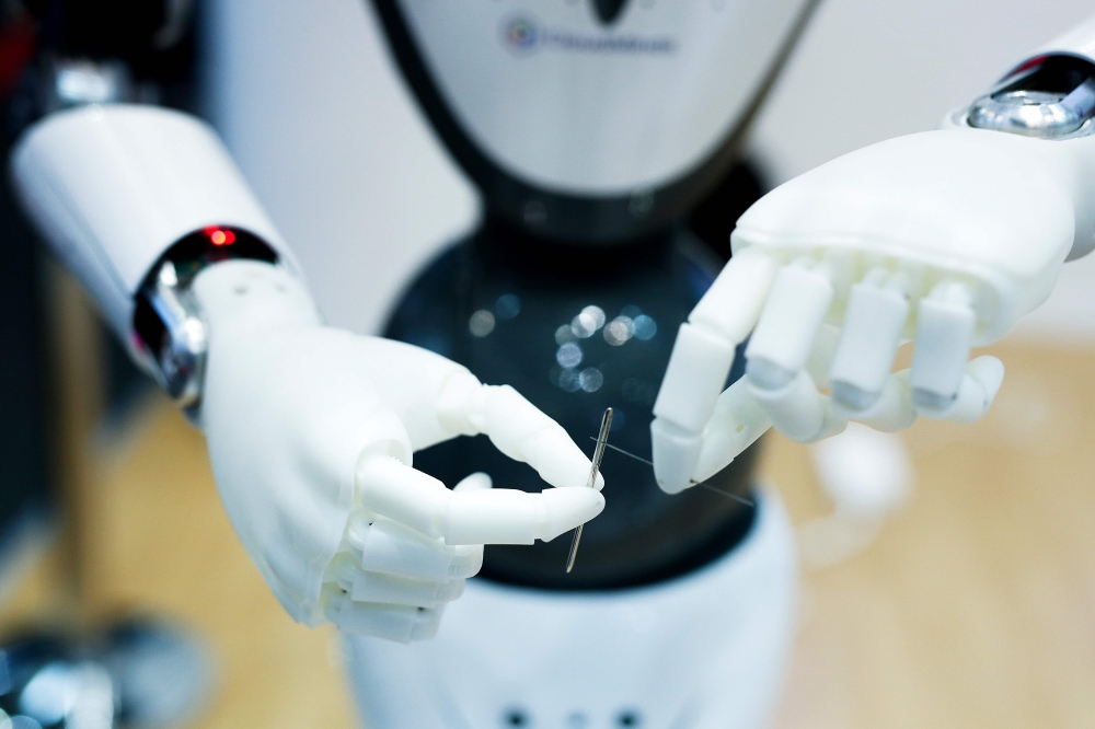 A CloudMinds robot uses a needle at the Mobile World Congress in Barcelona on February 26, 2019. AFP / Pau Barrena