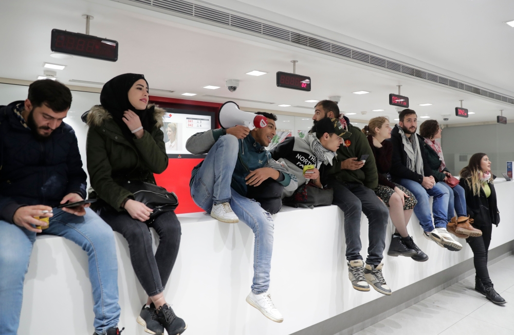 Lebanese protesters occupy a branch of BLC Bank in Beirut on December 28, 2019 in protest against nationwide imposed restrictions on dollar withdrawals and transfers abroad in an attempt to conserve dwindling foreign currency reserves.   AFP / ANWAR AMRO