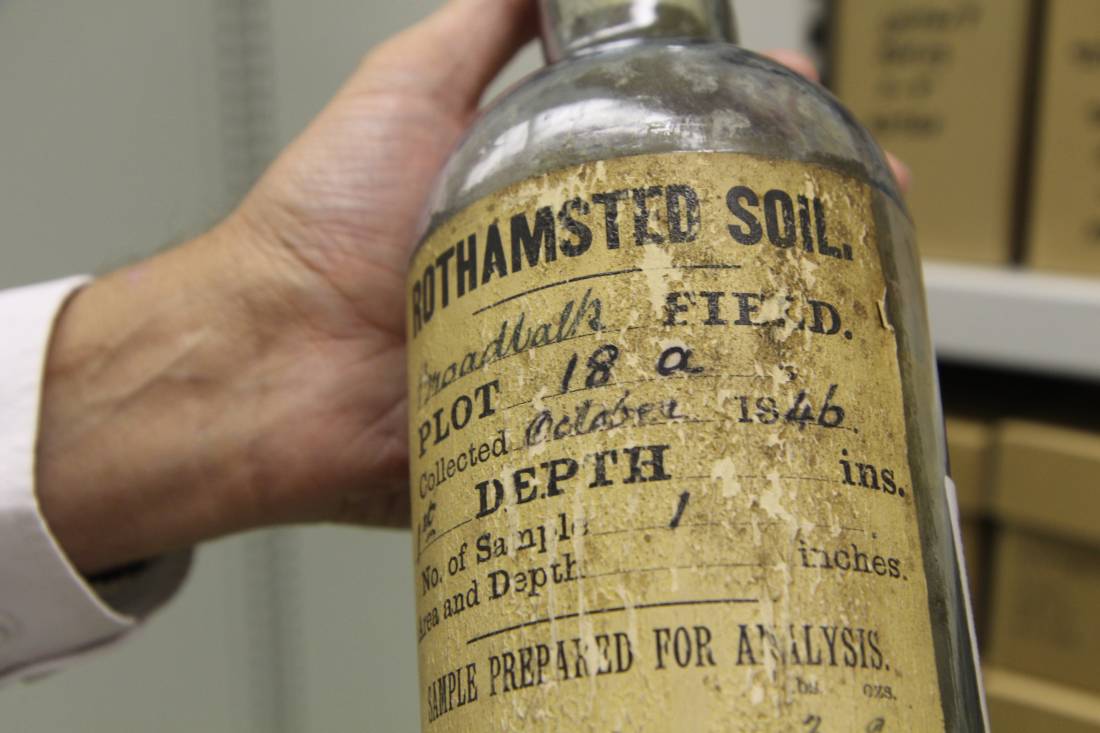 A scientist at Rothamsted Research holds a glass bottle with soil sample dating back to October 1846 in Harpenden in southeast England, September 12, 2019. Thomson Reuters Foundation / Thin Lei Win