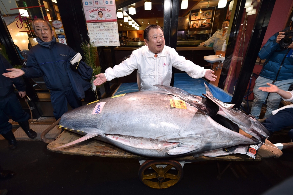 Kiyoshi Kimura (C), President of Kiyomura Corp., the Tokyo-based operator of sushi restaurant chain Sushizanmai, displays a 276-kilogram bluefin tuna that fetched 193.2 million yen (1.8 million USD) at his main restaurant in Tokyo on January 5, 2020 after