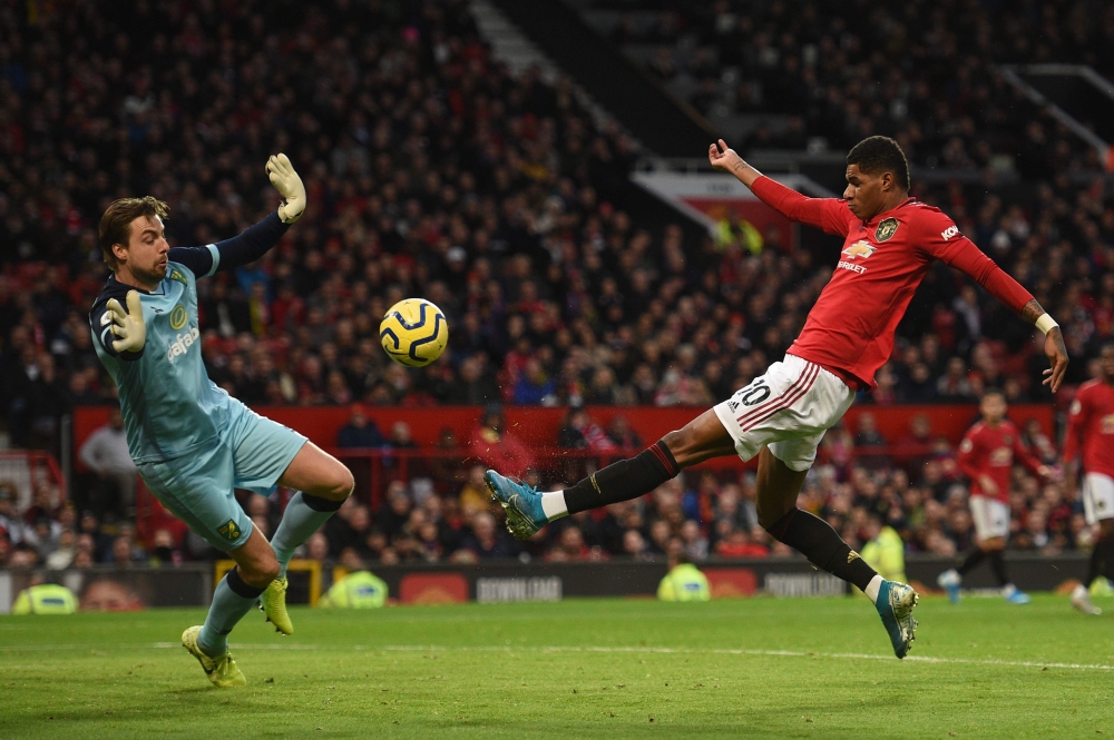 Manchester United's English striker Marcus Rashford (R) puts the ball past Norwich City's Dutch goalkeeper Tim Krul (L) to score the opening goal during the English Premier League football match between Manchester United and Norwich City at Old Trafford i