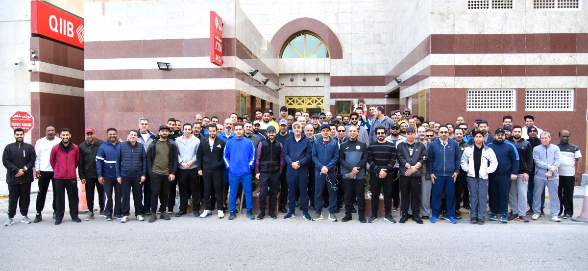 QIIB Chief Executive Officer, Dr Abdulbasit Ahmed Al Shaibei, with other employees of the Bank posing for a group photo at QIIB headquarters in Doha,  after the National Sport Day celebrations, yesterday. 