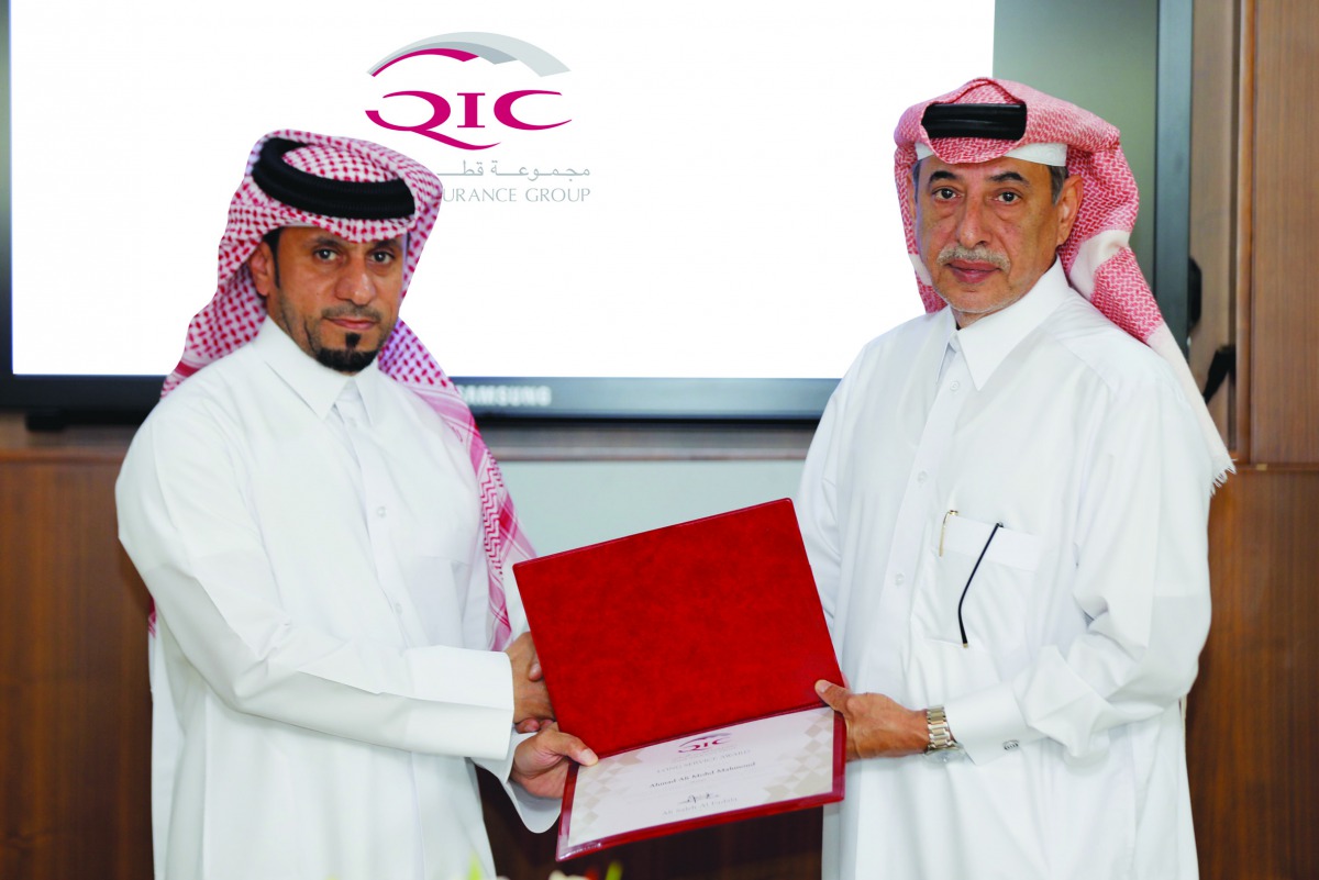 Ali Saleh Al Fadala (right), Senior Deputy Group President & CEO of QIC Group presenting the award to one of the long-serving employees at the ceremony. 