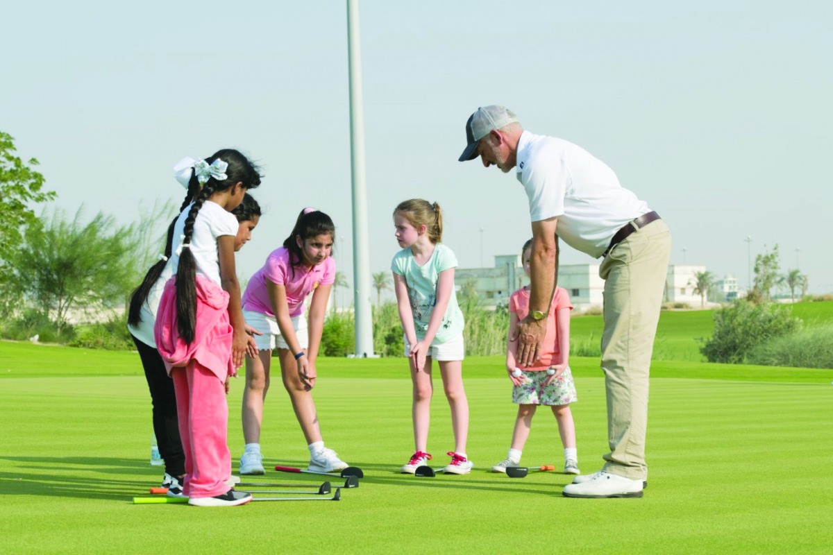 Young golfers receiving tips from a coach as they prepare for the Qatar Schools Golf Championship, scheduled to be held on February 22 at the Education City Golf Club.