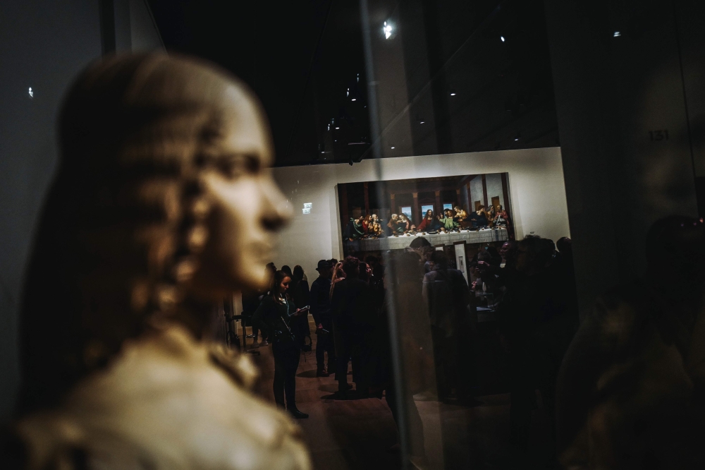 Visitors look at a version of 'The Last Supper' during the night and free opening of the 'Leonardo da Vinci' exhibition at The Louvre Museum on February 21, 2020, in Paris. AFP / LUCAS BARIOULET