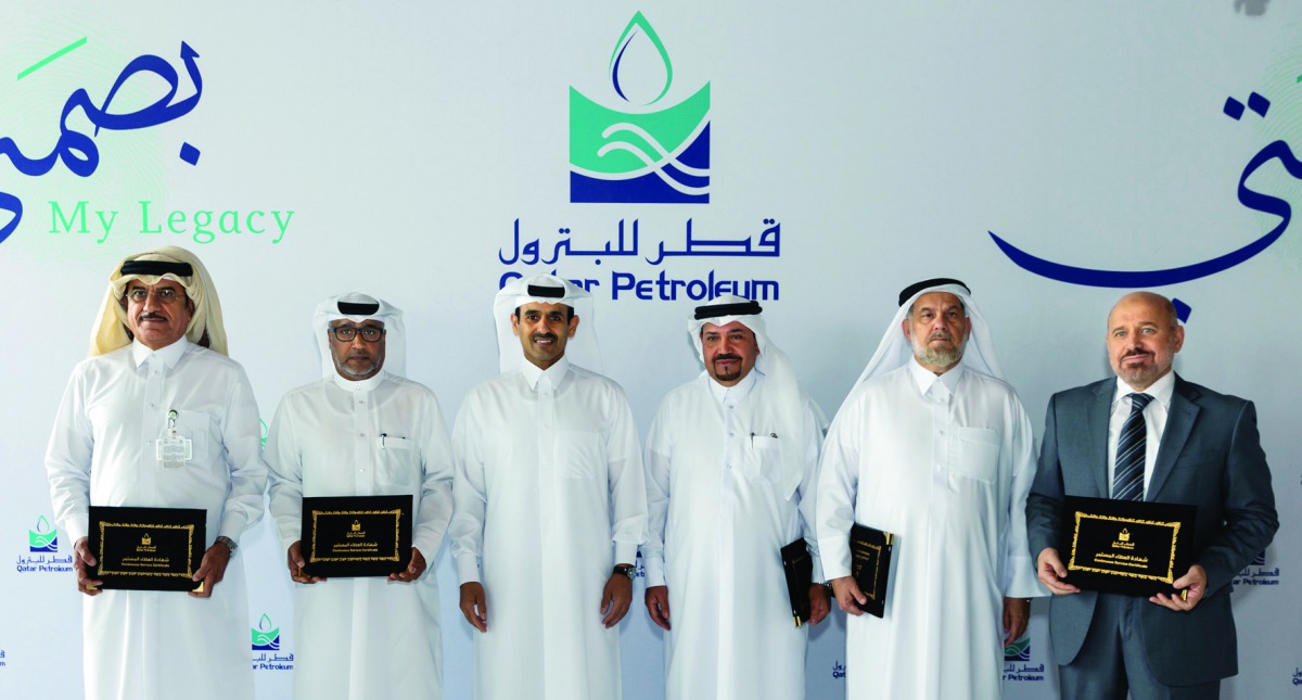H E Saad bin Sherida Al Kaabi (third left), the Minister of State for Energy Affairs, and President and CEO of Qatar Petroleum, posing for a group picture with some of the long-serving employees who were honoured, yesterday.