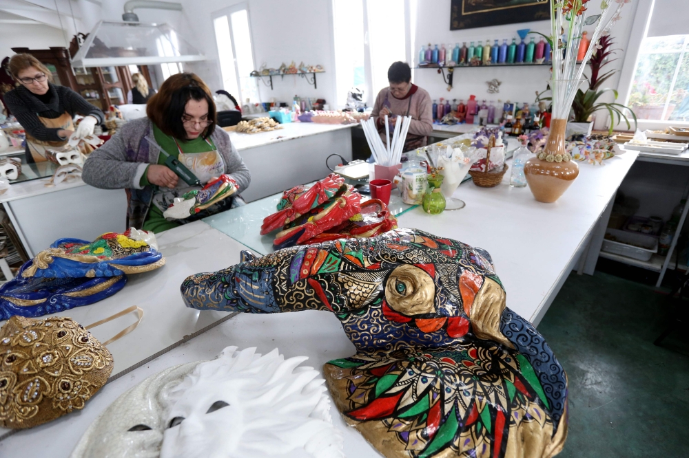 Artists work on a carnival mask at the Venice Art Mask workshop in Shkoder, Albania, on February 20, 2020. AFP / Gent Shkullaku 