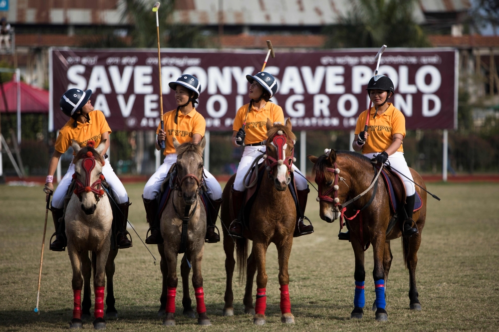 In this photograph taken on January 7, 2020, Thangmeiband Youth Polo Club players line up before their match against Linthoingambi Kangjei Lup polo club during the 15th Women's State Polo Tournament at the Mapal Kangjeibung (Polo Ground) in Imphal, the ca