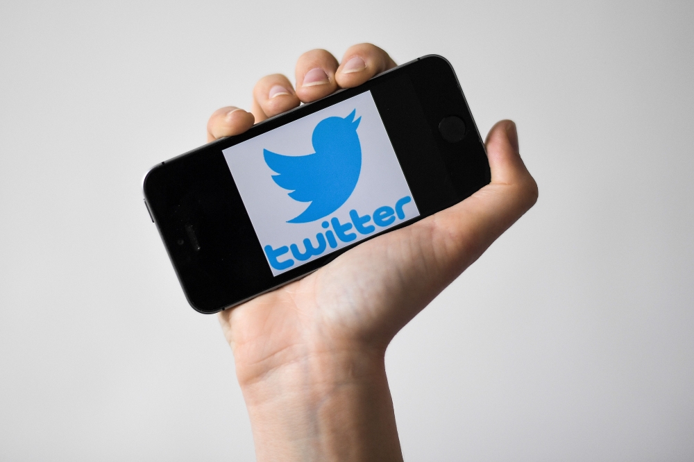 In this file photo taken on May 02, 2019 a woman shows a smartphone with the logo of US social network twitter, in Nantes, western France. twitter said March 4, 2020 it is testing a way for users to 