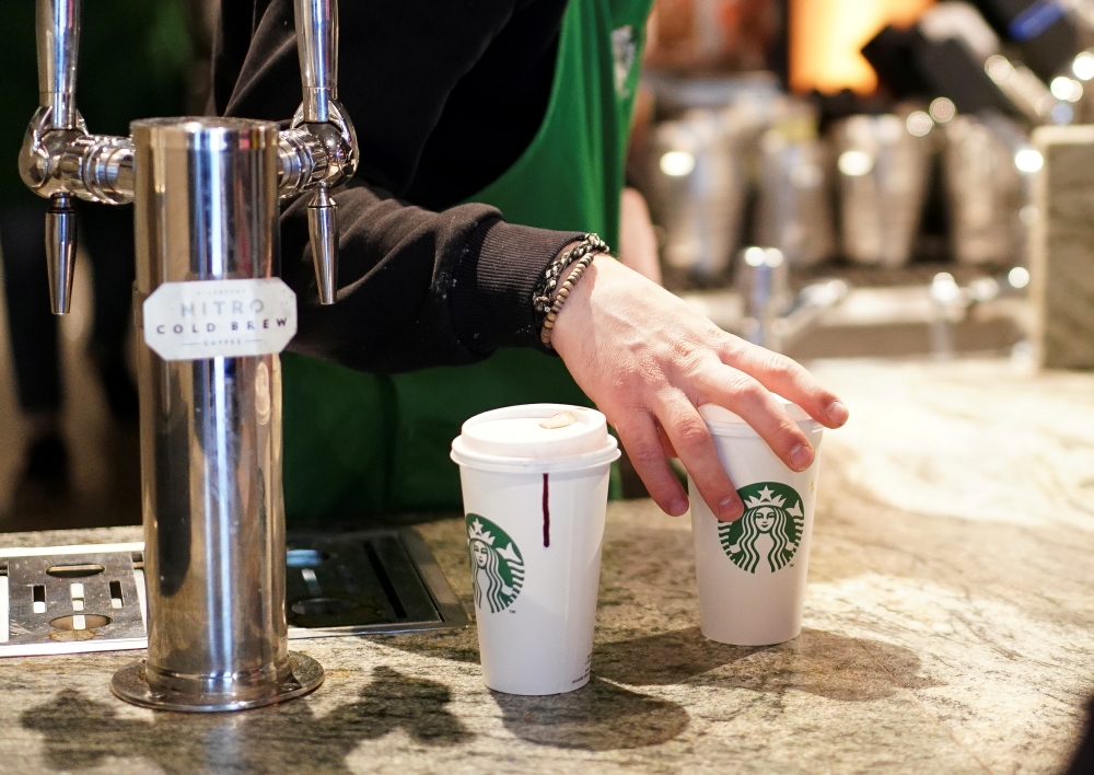 A barista serves beverages in single use cups inside a Starbucks in London, Britain, March 6, 2020. REUTERS/Henry Nicholls