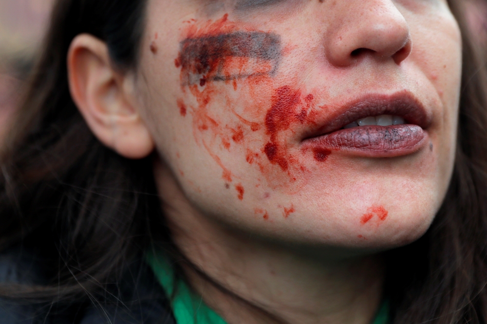 A demonstrator with paint on her face reacts during a protest to mark the International Women's Day in Madrid, Spain March 8, 2020. Reuters/Susana Vera
 
 