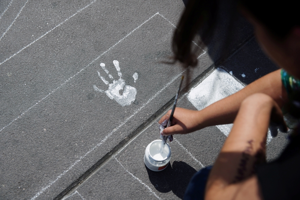 A woman paints the name of a femicide victim for a protest marking International Women's Day, at Zocalo square in Mexico City, Mexico March 8, 2020. Reuters/Ariana Drehsler
 