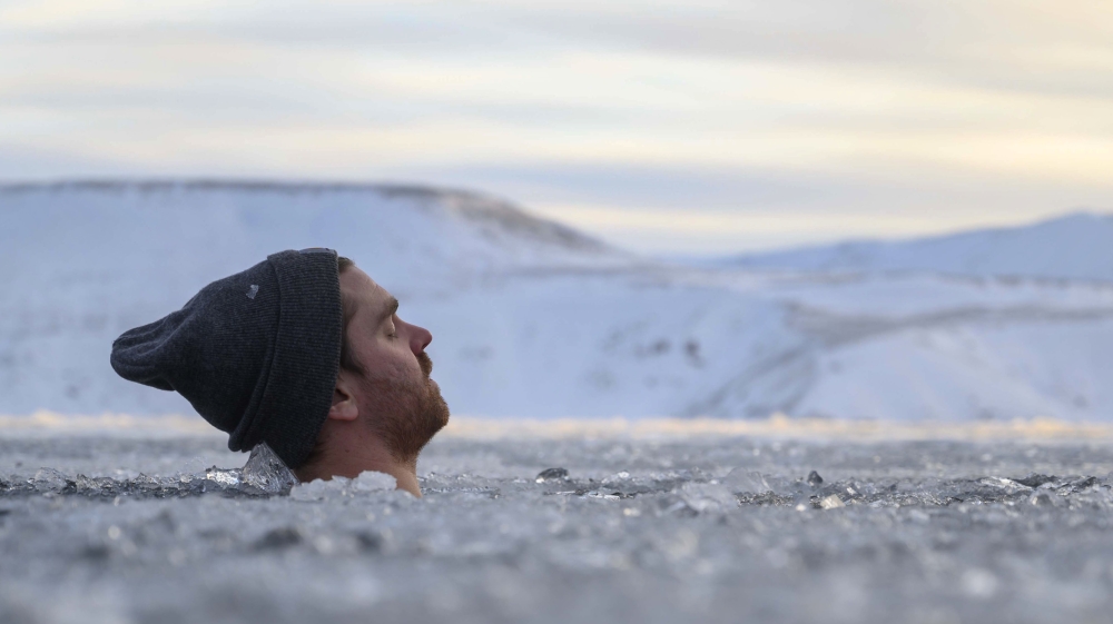 A participant baths in the waters of an ice-covered lake in southwestern Iceland during a seminar on February 1, 2020 in Kleyfarvatn, near Reykjavik. AFP / Halldor KOLBEINS