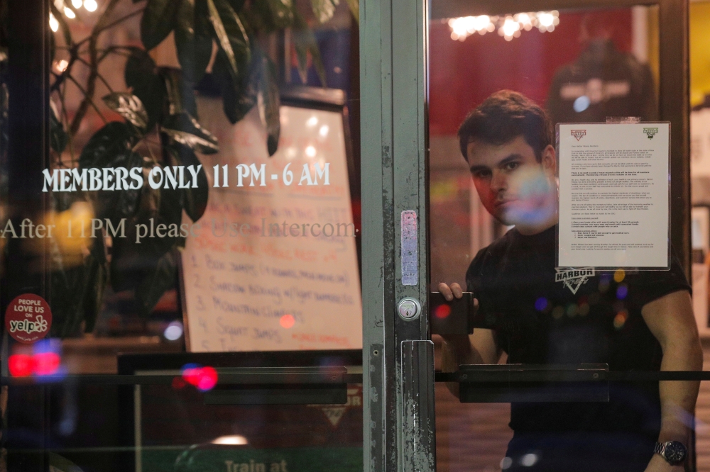 FILE PHOTO: An employee exits Harbor Fitness, following the citywide order to close gyms in the wake of the outbreak of coronavirus (COVID-19), in the Brooklyn borough of New York, U.S., March 16, 2020. REUTERS/Brendan McDermid/File Photo