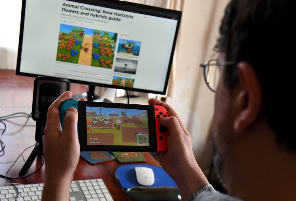 This photo taken on April 29, 2020 shows Australian high school teacher Dante Gabriele playing Nintendo's Animal Crossing at home in Melbourne during the country's enforced COVID-19 coronavirus lockdown. / AFP / William WEST /