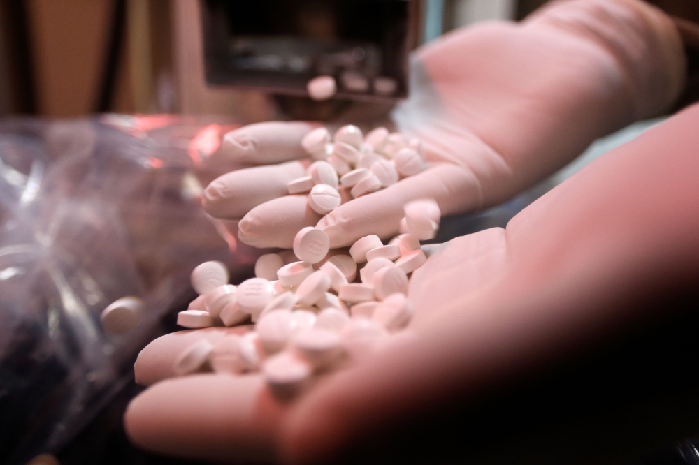 An employee of a pharmaceutical factory shows pills of the hydroxychloroquine drug, used to prevent or cure COVID-19, on April 28,2020  / AFP / LOUAI BESHARA