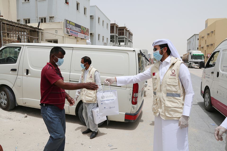 QFC and Qatar Charity officials giving away protective kits to Industrial Area workers 
