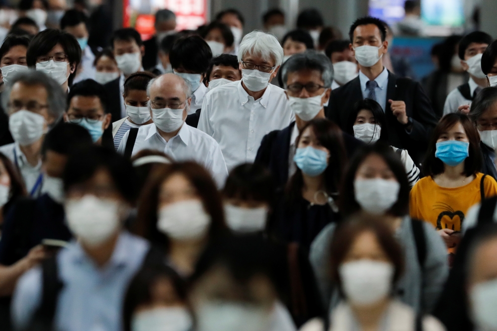 People wearing protective masks make their way during rush hour at Shinagawa station on the first day after the Japanese government lifted the state of emergency in Tokyo, Japan, May 26, 2020.REUTERS/Kim Kyung-Hoon
