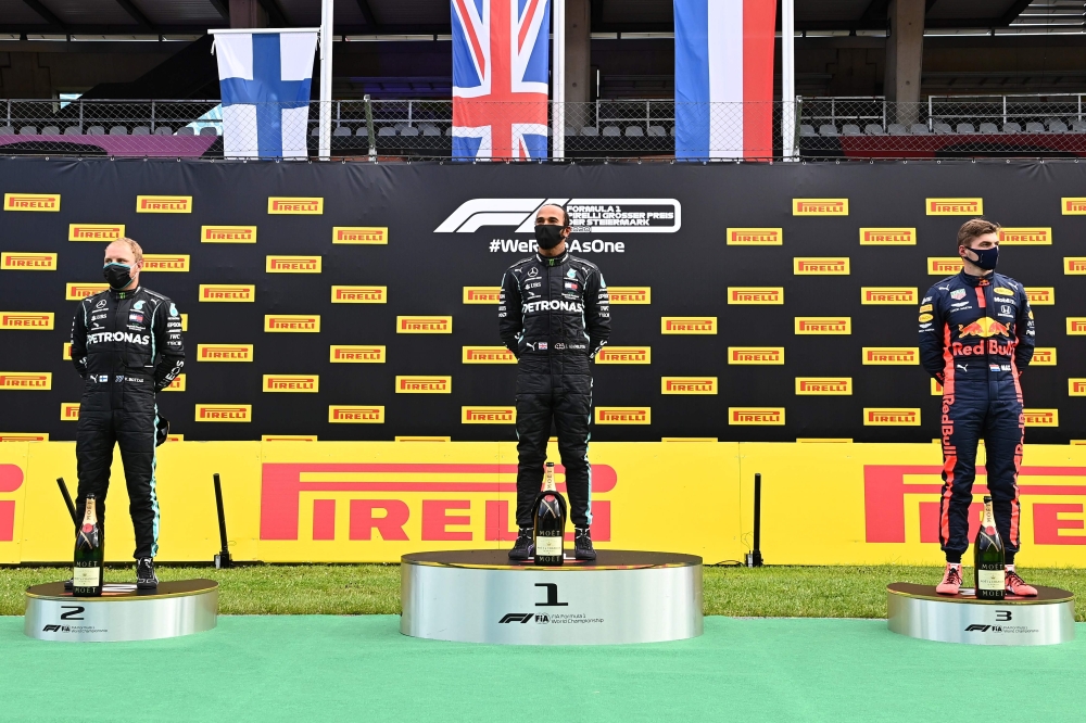 Mercedes' British driver Lewis Hamilton (C), second placed Mercedes' Finnish driver Valtteri Bottas (L) and third placed Red Bull's Dutch driver Max Verstappen celebrate on the podium after the Formula One Styrian Grand Prix race on July 12, 2020 in Spiel