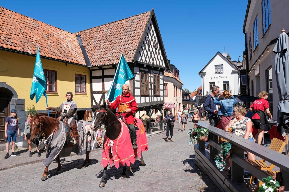 Thomas Lindgren (L) on the horse Soprano and Anders Mansson on Sara, both from the knight society Tornamenteum, patrol the city of Visby on the Swedish island of Gotland on July 23, 2020. Sweden OUT / AFP / TT NEWS AGENCY / TT News Agency / Soren ANDERSSO