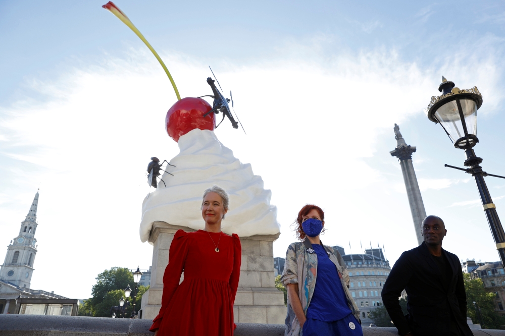 Deputy Mayor for Culture and Creative Industries Justine Simons OBE, Artist Heather Phillipson and Chair of the Fourth Plinth Comissioning Group Ekow Eshun pose next to Phillipson's sculpture ''THE END'', after it was unveiled on Trafalgar Square's Fourth