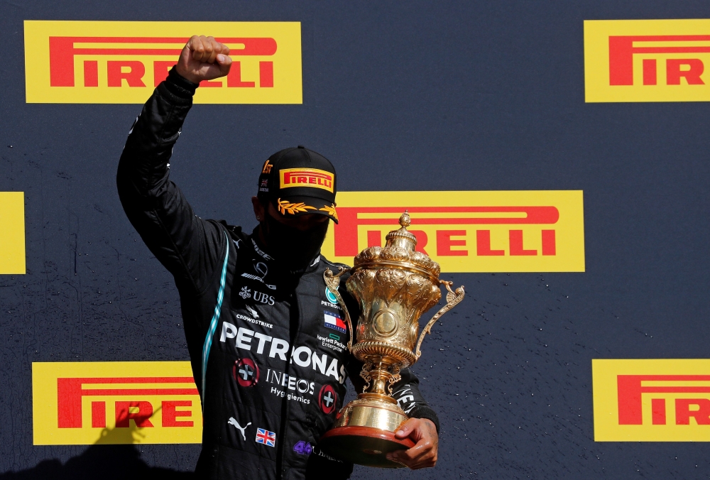 Winner Mercedes' British driver Lewis Hamilton celebrates with his trophy on the podium after the Formula One British Grand Prix at the Silverstone motor racing circuit in Silverstone, central England on August 2, 2020. (AFP / POOL / Frank Augstein)
 