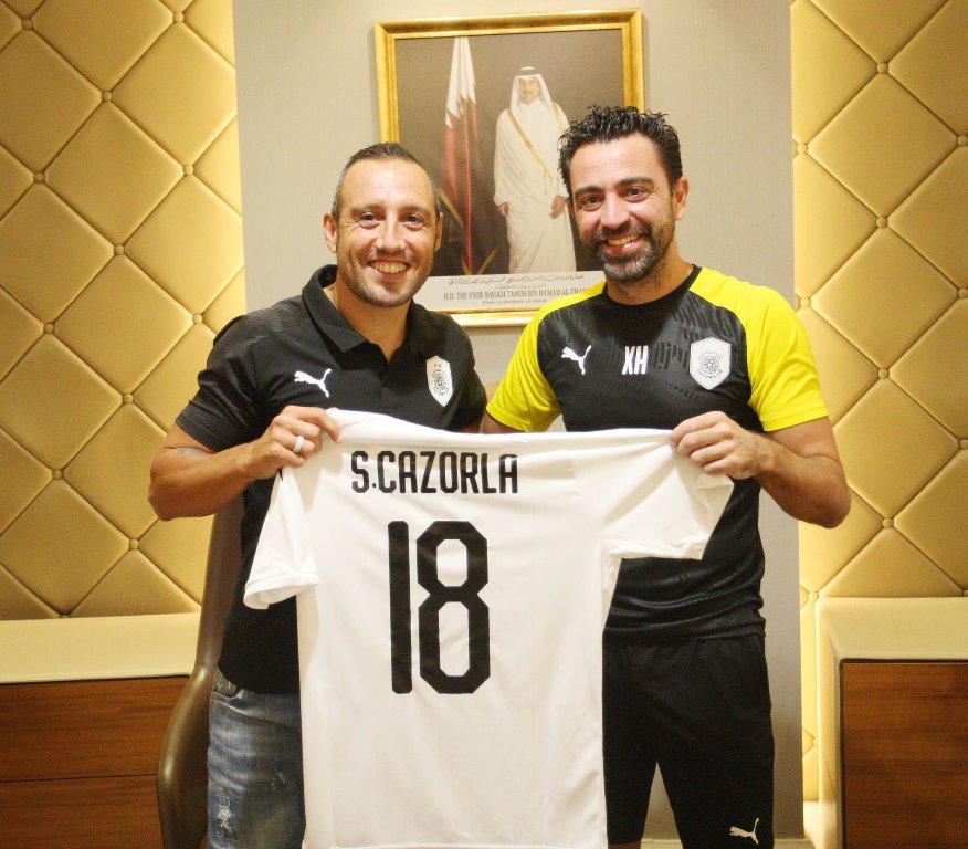 Al Sadd's latest recruit, Spanish star Santi Cazorla holding a team jersey with coach Xavi Hernandez during a ceremony held yesterday. The midfielder bid farewell to Villarreal few days ago. Cazorla had made 180 appearances over six years for Arsenal and 