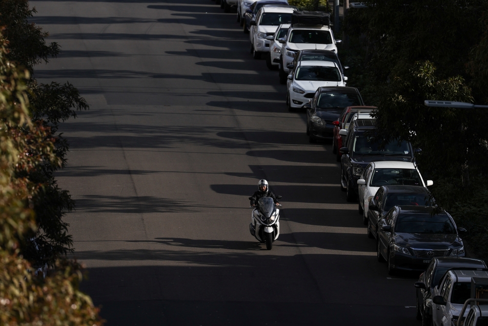 A delivery courier drives down an empty street as the state of New South Wales continues to report low numbers for new daily cases of the coronavirus disease (COVID-19) in Sydney, Australia, August 21, 2020. REUTERS/Loren Elliott