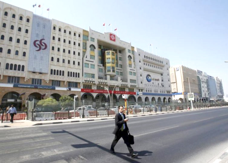 This file photo shows a man walking across the Grand Hamad Street, also known as the ‘Bank Street’ in Doha, Qatar. 