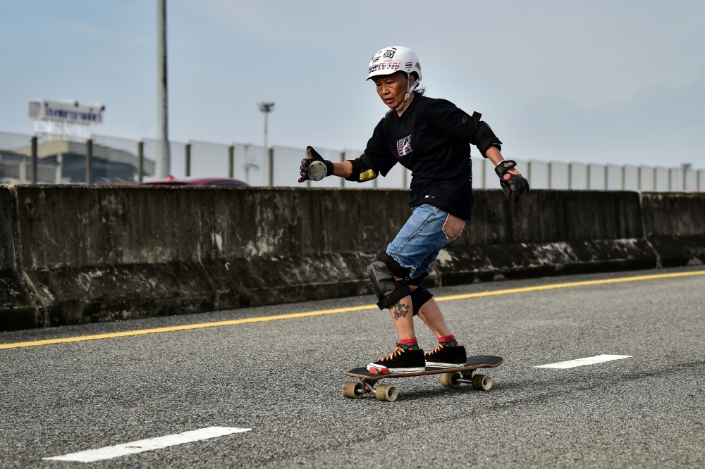 Longboarder and cancer survivor Nongluck Chairuettichai, also known as Jeab, during a practice session on an unfinished highway ramp in Bangkok. AFP / Lillian SUWANRUMPHA