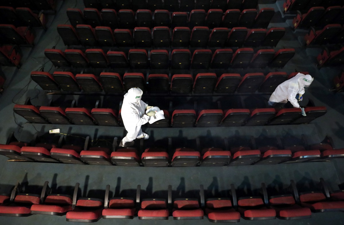 Workers wearing personal protective equipment (PPE) sanitize and clean the seats of Star theatre ahead of its reopening, amidst the outbreak of the coronavirus disease (COVID-19), in Kolkata, India, September 29, 2020. REUTERS/Rupak De Chowdhuri
