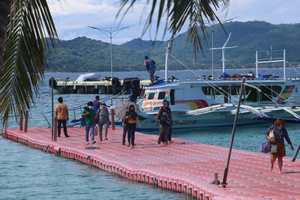 In this photo taken on October 1, 2020, residents arrive in Borocay, central Philippines. Authorities eased restrictions in the world-famous Boracay on October 1, allowing local tourists to visit the island after more than six months of quarantine as coro
