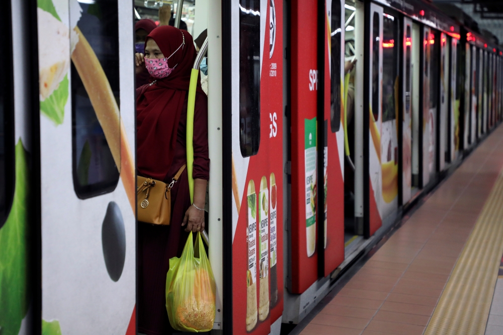 A woman wearing a protective face mask is seen in a Light Rail Transit train at a station, amid the coronavirus disease (COVID-19) outbreak in Kuala Lumpur, Malaysia October 1, 2020. REUTERS/Lim Huey Teng