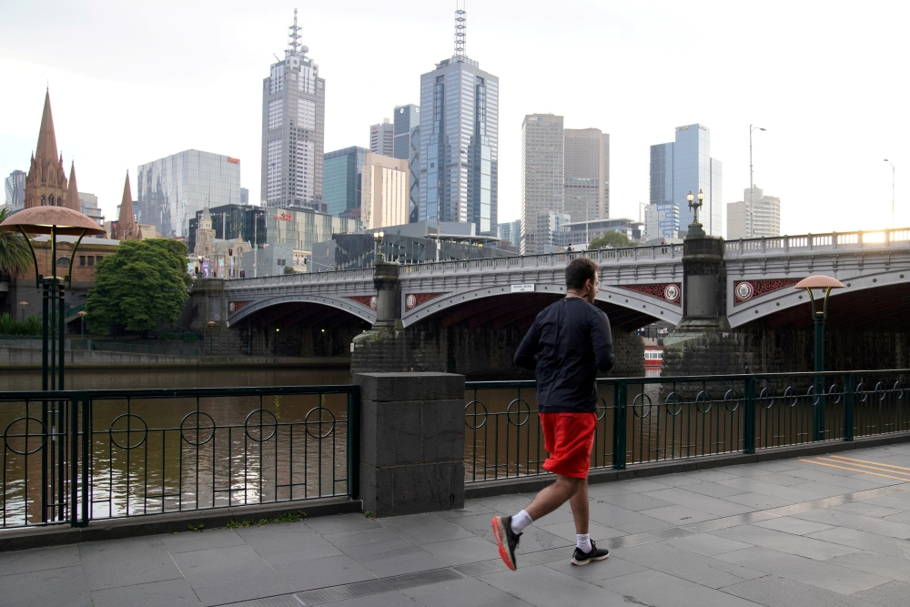 A man runs along a waterway after lockdown restrictions were implemented in response to an outbreak of the coronavirus disease (COVID-19) in Melbourne, Australia, July 10, 2020. REUTERS/Sandra Sanders/File Photo
