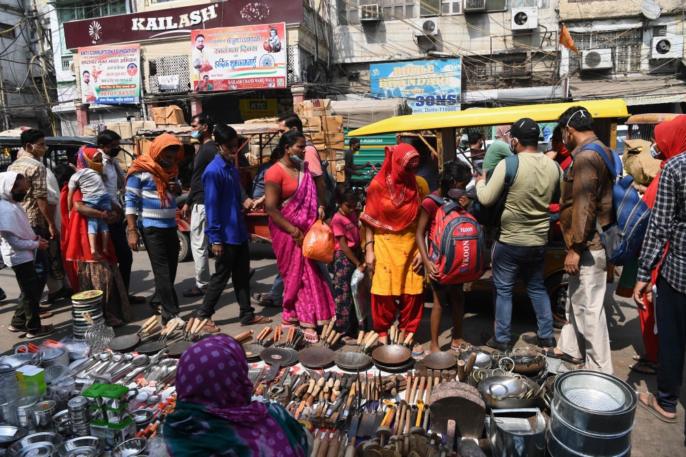 People wearing facemasks as a preventive measure against the Covid-19 coronavirus crowd in a market area in the old quarters of New Delhi on October 11, 2020. AFP / Sajjad Hussain 