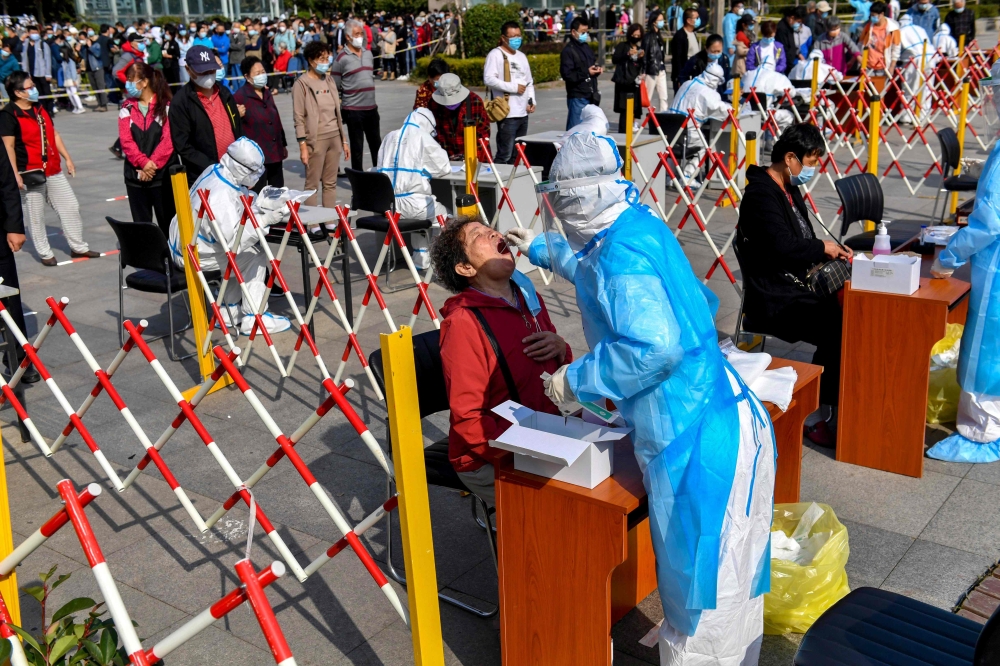 A health worker takes a swab from a resident to be tested for the COVID-19 coronavirus in Qingdao, in China's eastern Shandong province on October 12, 2020. China OUT / AFP / STR